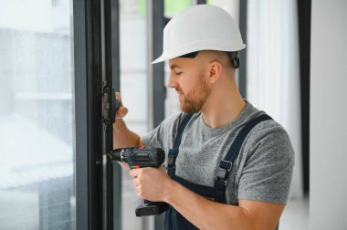 servis elemanı tornavidayla pencere kuruyor