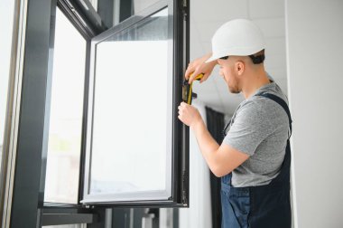 İnşaat işçisi eve pencere kuruyor