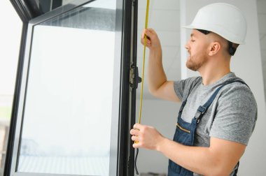 İnşaat işçisi eve pencere kuruyor