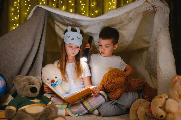 Familia Feliz Niños Leyendo Libro Con Una Linterna Una Tienda —  Fotos de Stock