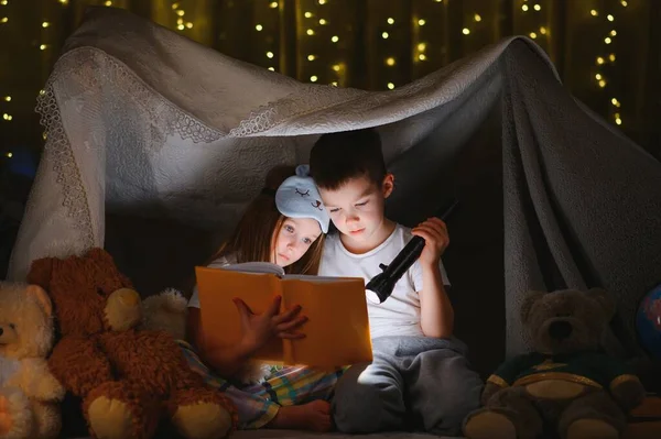 Dos Niños Con Linterna Leen Libro Debajo Una Manta Como —  Fotos de Stock