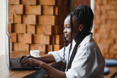 Mutlu Afrikalı Amerikan kadın işçisi Loft ofis veya kafede bilgisayarda dizüstü çalışma çalışması kullanarak, gülümseyen karışık yarış kadın öğrenci Freelancer kullanarak PC uygulaması dating iletişim çevrimiçi izleme Webinar