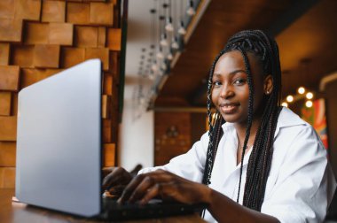 Kamera, poz, bilgisayarda çalışan, ödev yapmak, coffee House raporu hazırlanıyor heyecanlı erkek bakarak kafe, masada oturan mutlu gülümseyen Afrikalı-Amerikalı kadın portresi kafa vurdu