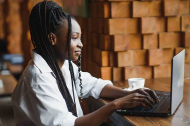 Bilgisayara bakan Afro-Amerikalı genç iş kadını ya da öğrenci, bilgisayarla çalışan ya da çalışan ciddi siyahi kadın ya da internetten sınava hazırlanan
