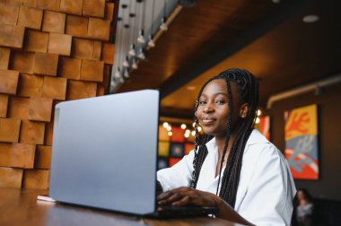 Bilgisayara bakan Afro-Amerikalı genç iş kadını ya da öğrenci, bilgisayarla çalışan ya da çalışan ciddi siyahi kadın ya da internetten sınava hazırlanan