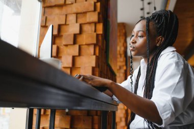 Mutlu Afrikalı Amerikan kadın işçisi Loft ofis veya kafede bilgisayarda dizüstü çalışma çalışması kullanarak, gülümseyen karışık yarış kadın öğrenci Freelancer kullanarak PC uygulaması dating iletişim çevrimiçi izleme Webinar