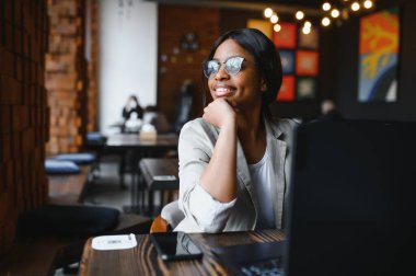 Mutlu Afrikalı Amerikan kadın işçisi Loft ofis veya kafede bilgisayarda dizüstü çalışma çalışması kullanarak, gülümseyen karışık yarış kadın öğrenci Freelancer kullanarak PC uygulaması dating iletişim çevrimiçi izleme Webinar