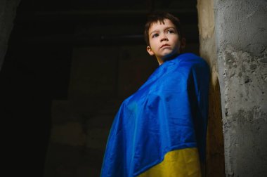 Ukrayna bayrağına sarılı üzgün bir Ukraynalı çocuk Mariupol ya da Kiev 'deki bir sığınakta bombalardan saklanıyor. Rusya 'nın saldırganlığı. Ukrayna ve 2022 'deki savaş..