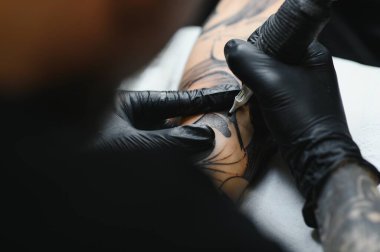 Kolunda makine dövmesi olan dövmeci tasarım, sanat ve tasarım konsepti çizilmiş.