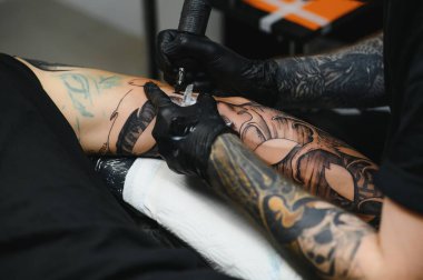 Kolunda makine dövmesi olan dövmeci tasarım, sanat ve tasarım konsepti çizilmiş.