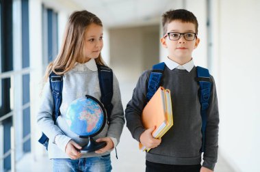 Okul üniformalı çocuklar koridorda beraberler. Eğitim kavramı.