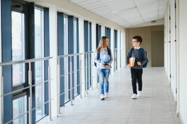 Okulda okul çantası ve kitapları olan bir öğrenci. Eğitim konsepti. Okula dönelim. Okul çocuğu sınıfa gidiyor. Sırt çantalı şık çocuk. Çocuk çalışmaya hazır..