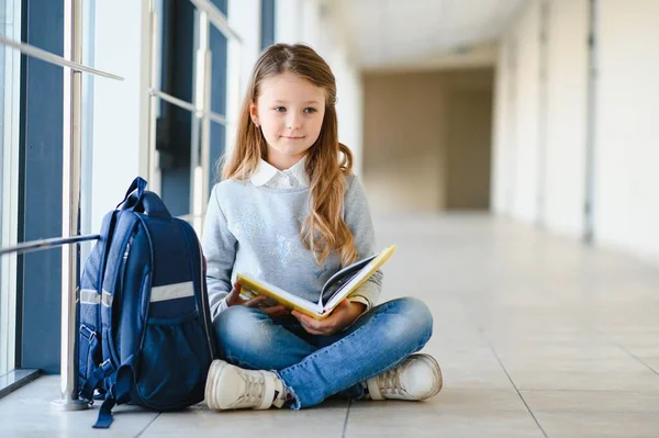 Kleines Hübsches Mädchen Sitzt Auf Dem Fußboden Des Schulflurs Und — Stockfoto