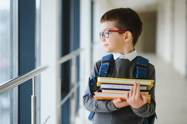 学校では通学用のかばんと本を持っている少年 教育の概念 学校に戻る 小学生は授業に行く バックパック付きのスタイリッシュな男の子 勉強の準備ができている少年 — ストック写真