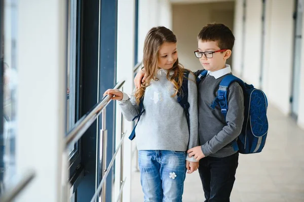 Okul üniformalı çocuklar koridorda beraberler. Eğitim kavramı.