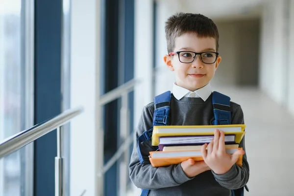 学校では通学用のかばんと本を持っている少年 教育の概念 学校に戻る 小学生は授業に行く バックパック付きのスタイリッシュな男の子 勉強の準備ができている少年 — ストック写真