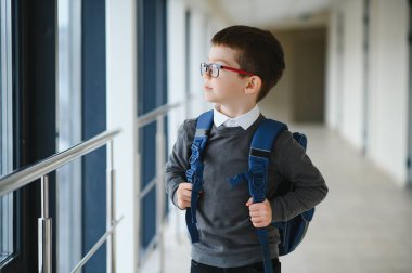 Okulda okul çantası ve kitapları olan bir öğrenci. Eğitim konsepti. Okula dönelim. Okul çocuğu sınıfa gidiyor. Sırt çantalı şık çocuk. Çocuk çalışmaya hazır..