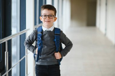 Okulda okul çantası ve kitapları olan bir öğrenci. Eğitim konsepti. Okula dönelim. Okul çocuğu sınıfa gidiyor. Sırt çantalı şık çocuk. Çocuk çalışmaya hazır..