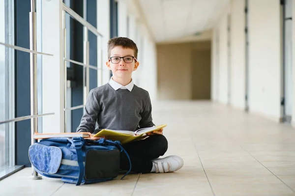 学校では通学用のかばんと本を持っている少年 教育の概念 学校に戻る 小学生は授業に行く バックパック付きのスタイリッシュな男の子 勉強の準備ができている少年 — ストック写真