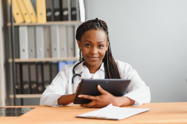 Parlak modern hastanede hastanın dosyası dijital tablet tutan kadın doktor portresi