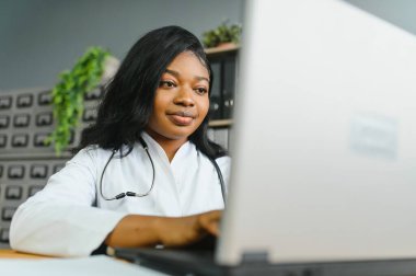 Afrikalı kadın doktor çevrimiçi teletıp görüntülü arama hastası yapıyor. Afro-Amerikalı siyahi kadın terapist uzaktan video konferans sohbetinde kamerayla konuşuyor. Web kamerası görüntüsü, yüz görüntüsü