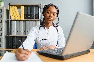 Afrikalı kadın doktor hastalarla teletıp internet üzerinden görüntülü konuşma yapıyor. Uzaktan kumandalı bilgisayardaki kadın terapist görüntülü konferans bilgisayarında sanal sohbet. TeleHealth konsepti