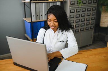 Sağlık, tıbbi ve teknoloji konsepti - dizüstü bilgisayarı olan Afrikalı kadın doktor.