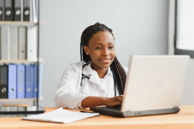 Afrikalı kadın doktor çevrimiçi teletıp görüntülü arama hastası yapıyor. Afro-Amerikalı siyahi kadın terapist uzaktan video konferans sohbetinde kamerayla konuşuyor. Web kamerası görüntüsü, yüz görüntüsü