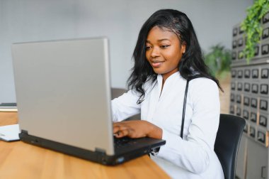 Sağlık, tıbbi ve teknoloji konsepti - dizüstü bilgisayarı olan Afrikalı kadın doktor.