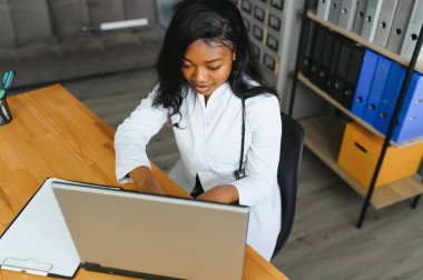 Afrikalı kadın doktor hastalarla teletıp internet üzerinden görüntülü konuşma yapıyor. Uzaktan kumandalı bilgisayardaki kadın terapist görüntülü konferans bilgisayarında sanal sohbet. TeleHealth konsepti