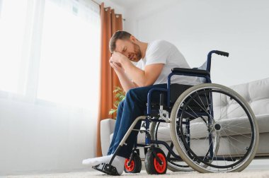 Evde acı çeken engelli genç adam.