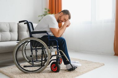 Özürlü bir adamda depresyon ve yalnızlık. Tekerlekli sandalyedeki yaşlı adam içeride ağlıyor.