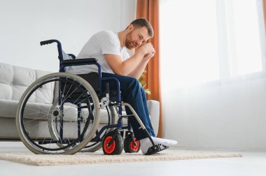 Özürlü bir adamda depresyon ve yalnızlık. Tekerlekli sandalyedeki yaşlı adam içeride ağlıyor.