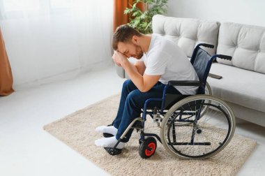 Özürlü bir adamda depresyon ve yalnızlık. Tekerlekli sandalyedeki yaşlı adam içeride ağlıyor.