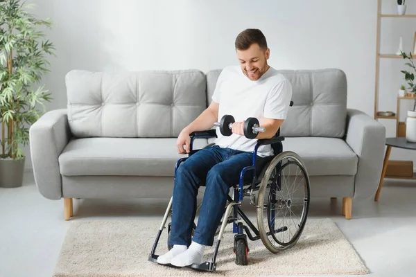 在现代医疗中心的康复活动中 运动员坐在轮椅上 用哑铃伸出手臂 坐在轮椅上的男人 — 图库照片