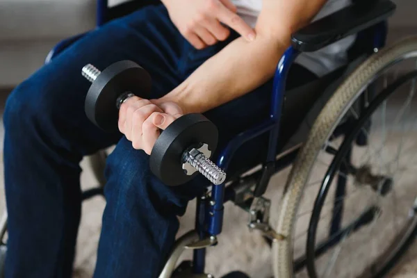 Man Disabled. Sports for Disabled. Male in Wheelchair with Dumbbells in Hands. Man with Dumbbells in Hands. Father Disabled Do Spotting. Sport at Apartment. Health Concept. Healthy Lifestyle.