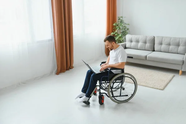 Portret Uśmiechniętego Niepełnosprawnego Mężczyzny Siedzącego Wózku Inwalidzkim Pracującego Laptopie Domu — Zdjęcie stockowe