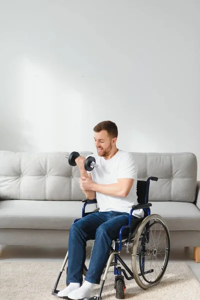在现代医疗中心的康复活动中 运动员坐在轮椅上 用哑铃伸出手臂 坐在轮椅上的男人 — 图库照片