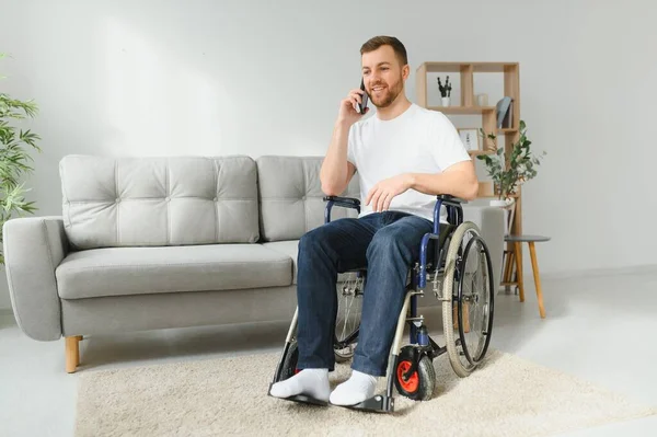 Der Behinderte Sitzt Rollstuhl Spricht Mit Jemandem Auf Seinem Smartphone — Stockfoto