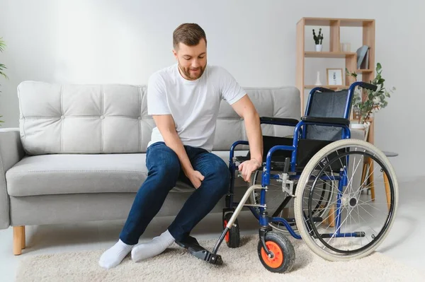 Deficiente Homem Casa Tenta Chegar Seus Pés Uma Cadeira Rodas — Fotografia de Stock