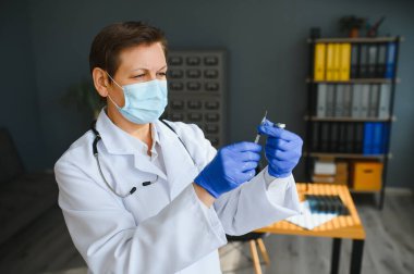 Ellerini, tıbbi şırınga ile doktor enjeksiyon için hazırlanıyor