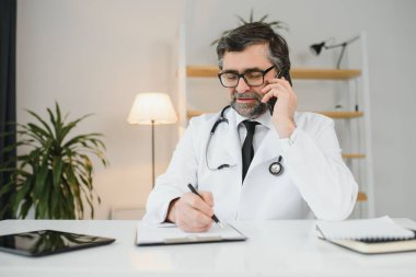 bir cep telefonu kullanarak profesyonel kolay kıdemli doktor portresi