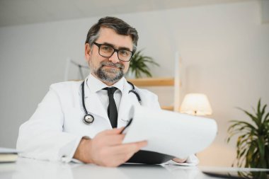 İş yerinde beyaz önlüklü kıdemli doktorun portresi.