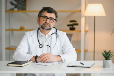 İş yerinde beyaz önlüklü kıdemli doktorun portresi.