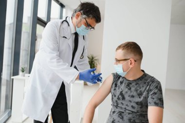 Yüz maskeli bir adam aşı oluyor, koronavirüs, covid-19 ve aşı konsepti..
