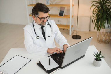 İş yerinde beyaz önlüklü kıdemli doktorun portresi.