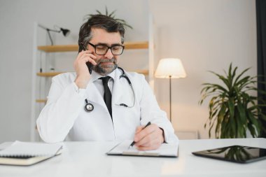 bir cep telefonu kullanarak profesyonel kolay kıdemli doktor portresi