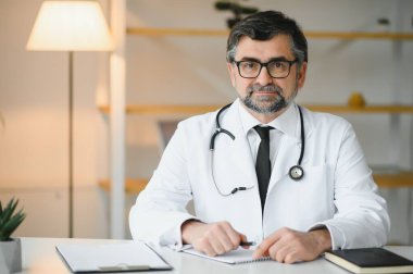 İş yerinde beyaz önlüklü kıdemli doktorun portresi.