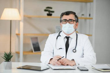 Koruyucu maske takan orta yaşlı bir doktorun portresi. Corona virüsü konsepti