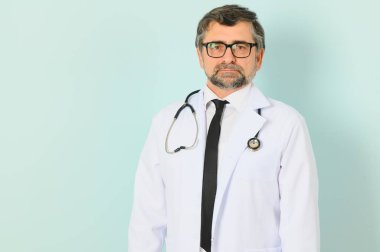 Mavi Stüdyo Arkaplan 'da Beyaz Üniformalı Profesyonel Doktor Adam pozu. Boşluğu Kopyalayan Panorama